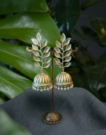 Load image into Gallery viewer, Pair of oxidized silver Jhumka earrings featuring a vertical leaf motif and pearl beads, displayed on a professional dark grey fabric background with green monstera leaves.