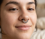 Load image into Gallery viewer, Close-up of a woman wearing an oxidized silver septum ring with intricate tribal detailing, styled in a natural minimal look.