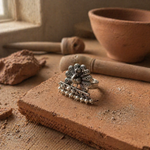 Load image into Gallery viewer, Oxidized silver peacock statement ring with engraved tribal detailing and small pearl drops, placed on a rustic terracotta surface in warm natural light.
