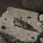 Load image into Gallery viewer, Oxidized silver statement ring with tribal procession design and pearl drops, placed on a textured stone surface with dramatic natural lighting.

